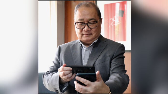 PLDT’s Manny Pangilinan shows off Smart’s 5G speeds using a Huawei 5G phone