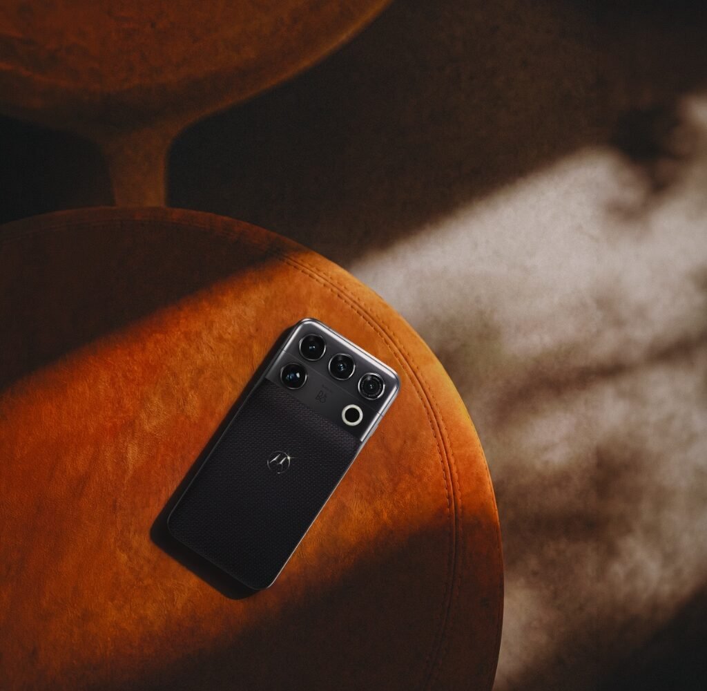 Motorola Signature 27 flagship smartphone in Coal Smoke Tactical Weave resting on orange suede