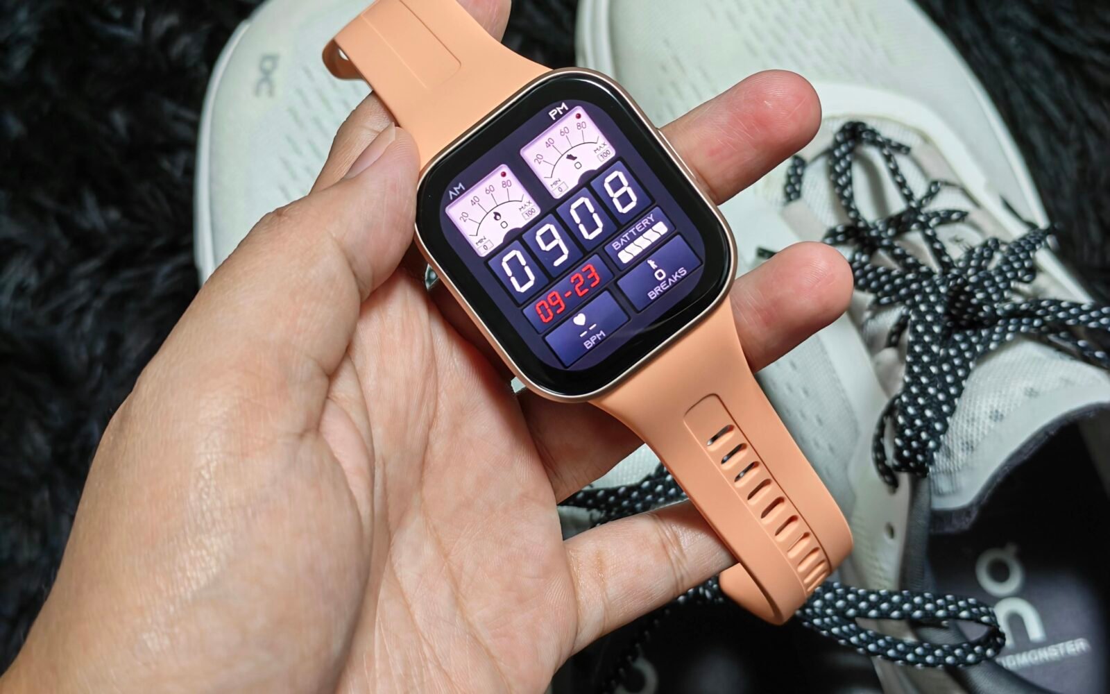 Holding a smartwatch against a white running shoes
