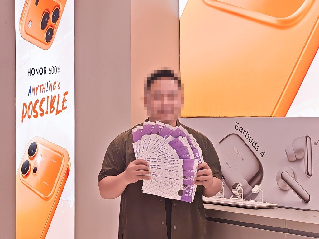 Customer holding a massive stack of HONOR 600S pre-order cards