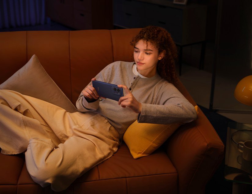 POCO C95 Pro in Blue held comfortably on a couch